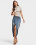 Woman wearing a beige top and denim skirt on a white background