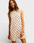 Woman wearing a patterned dress on a plain background