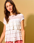Woman wearing a white lace top with a plain background