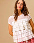 Woman wearing a white lace top with a beige background