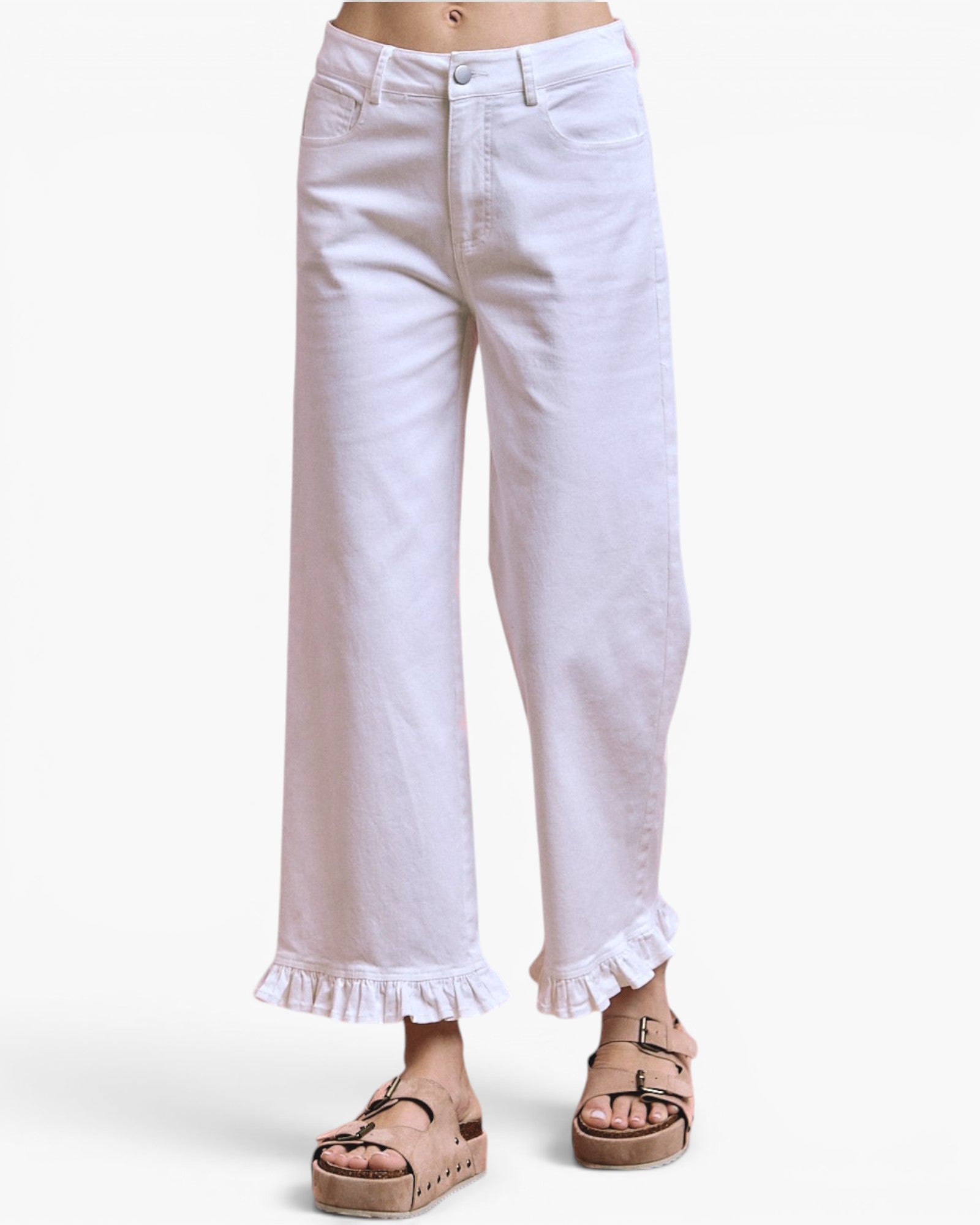 White cropped wide-leg jeans with a ruffled hem, shown on a model wearing brown platform sandals against a light gray background.