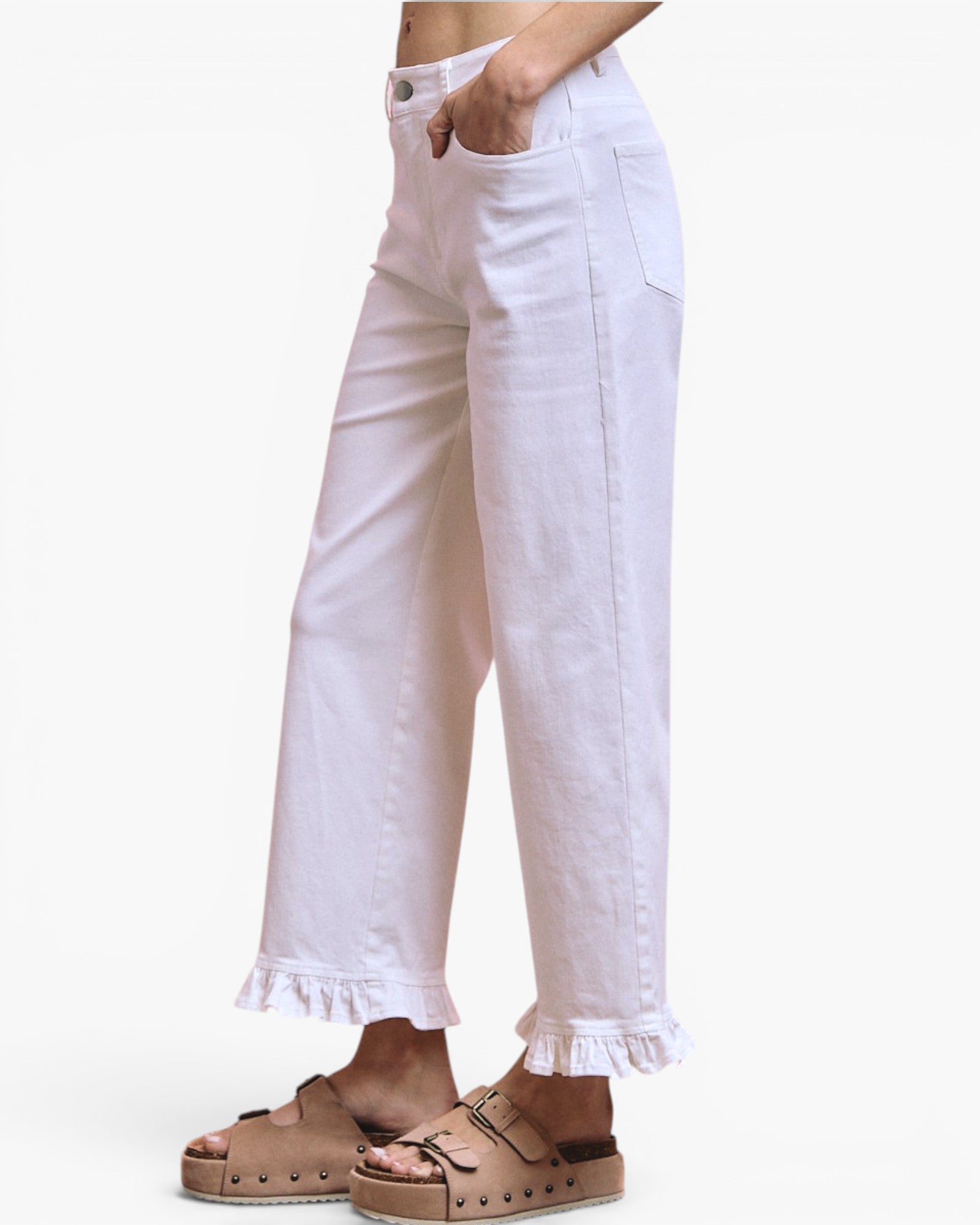 White wide-leg cropped pants with a ruffled hem, shown on a model wearing tan platform slide sandals against a plain white background.