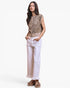 A woman modeling a sleeveless leopard-print vest with a front zipper, paired with white wide-leg jeans and brown sandals, against a plain light gray studio background.