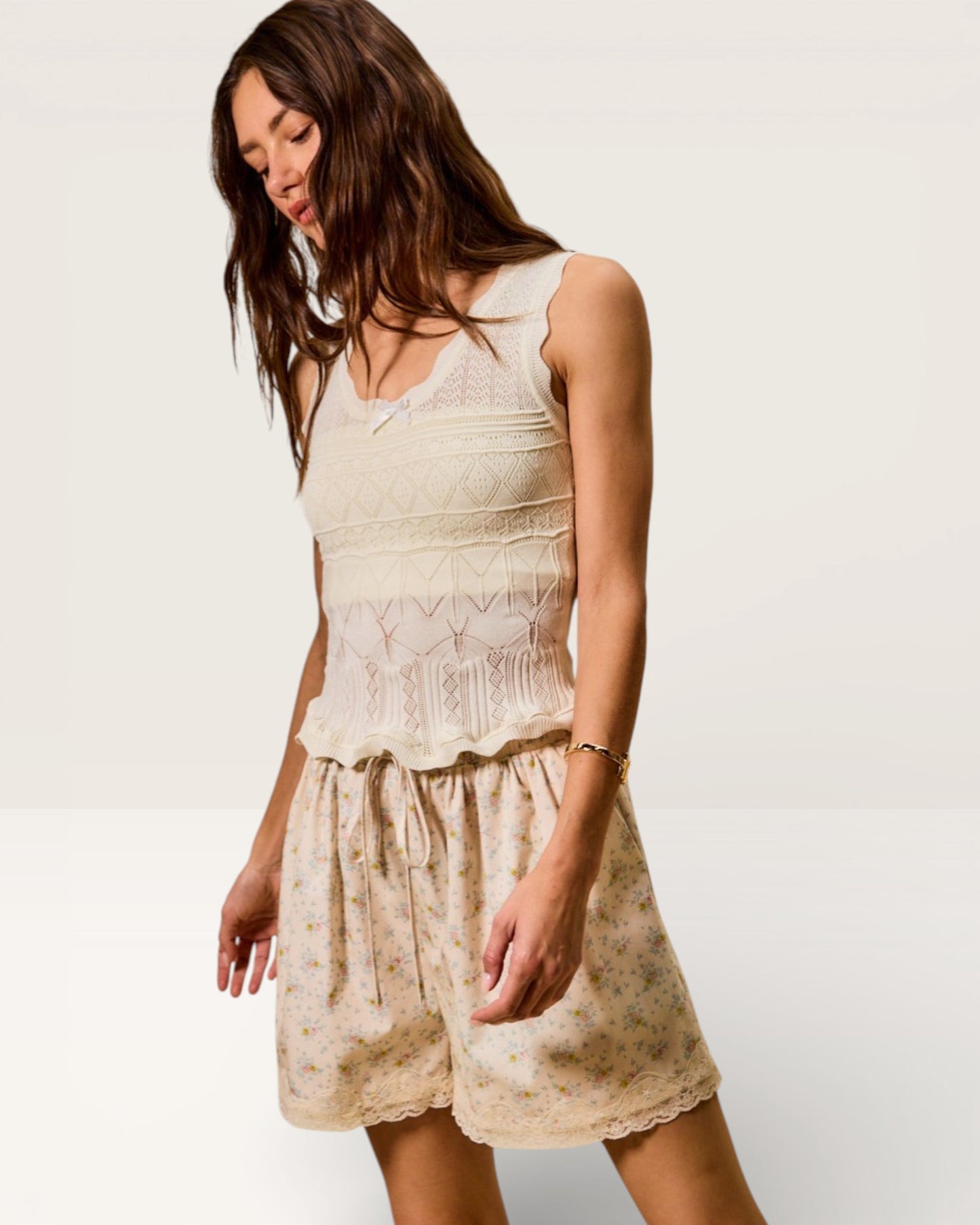 Woman wearing a white lace dress against a plain background