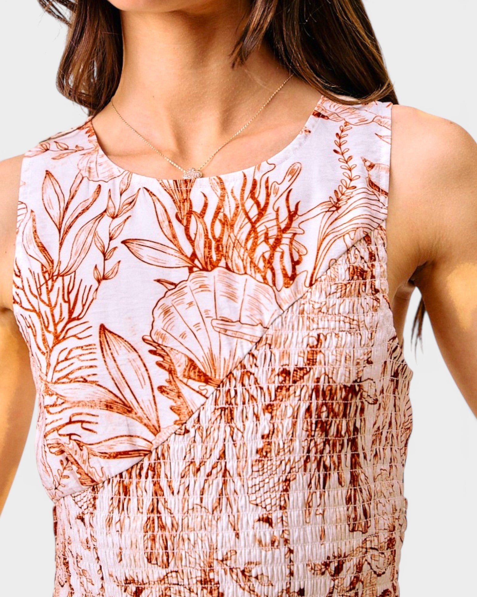 Close-up of a sleeveless top with floral pattern on a plain background