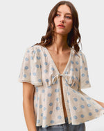 Woman wearing a polka dot blouse with a white background