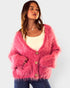 Woman wearing a pink fuzzy cardigan on a light gray background