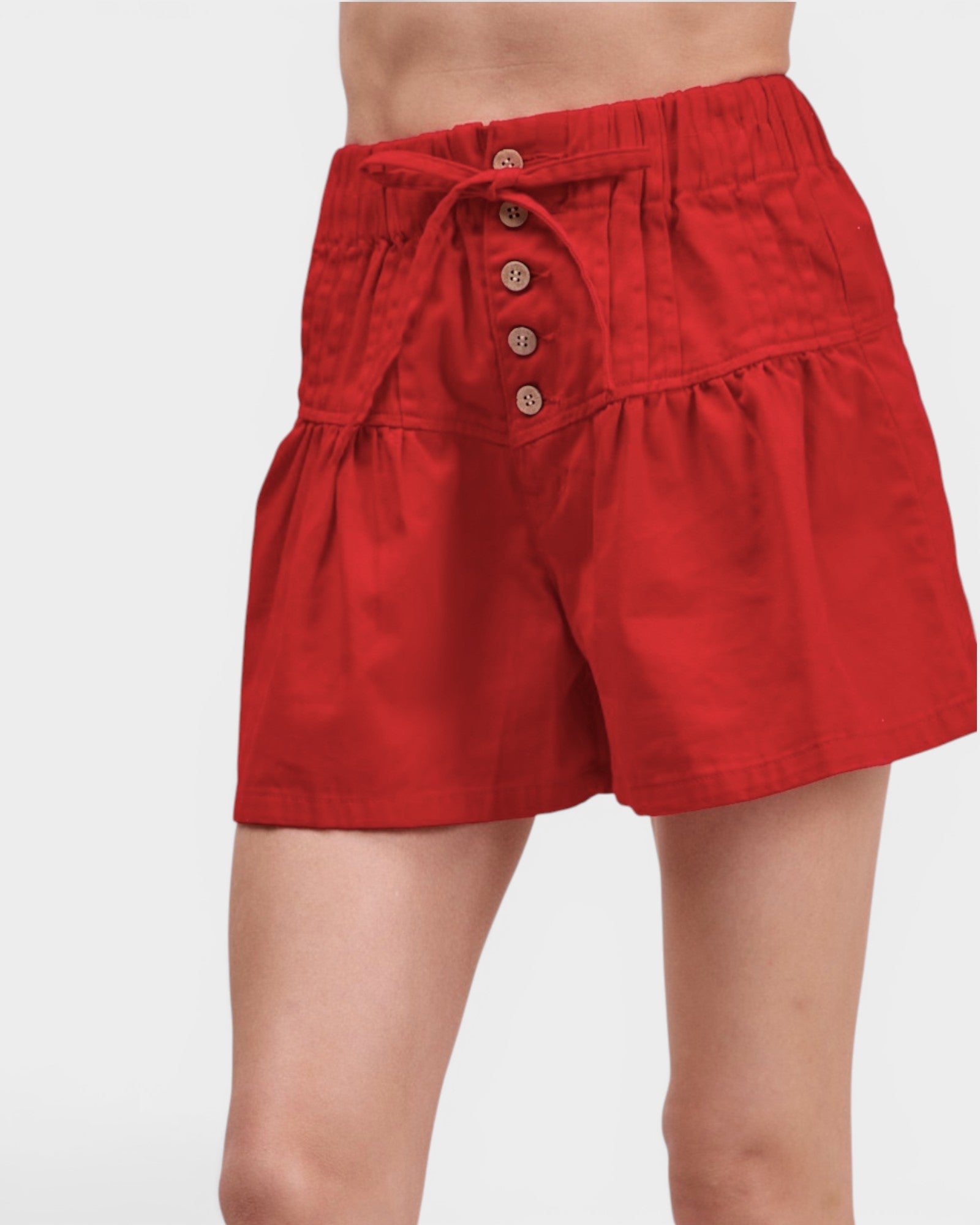Red shorts with button details on a white background