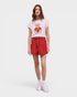 Woman wearing a white t-shirt with a bear graphic and red shorts on a white background