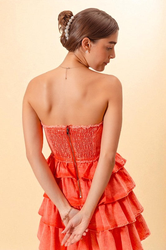 Woman wearing a coral strapless dress with a beige background