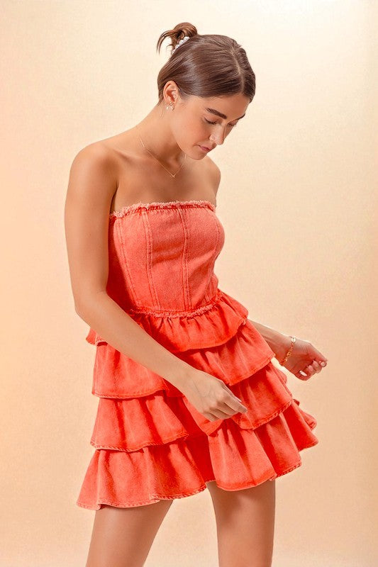 Woman wearing a coral strapless dress against a beige background