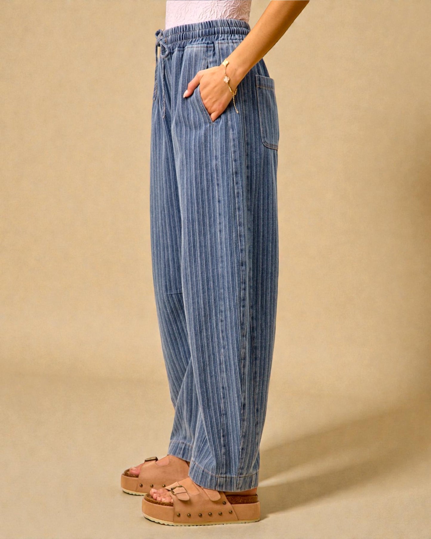 Person wearing blue striped pants on a beige background