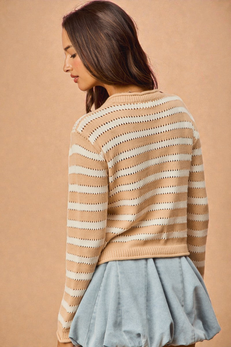 Woman wearing a striped sweater and denim skirt against a beige background
