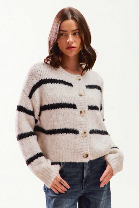 Woman wearing a striped cardigan with black and white stripes on a white background