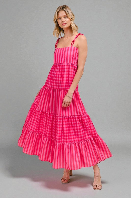 Woman wearing a pink checkered dress on a gray background