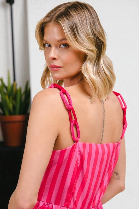 Woman wearing a pink and white striped dress with a blurred background