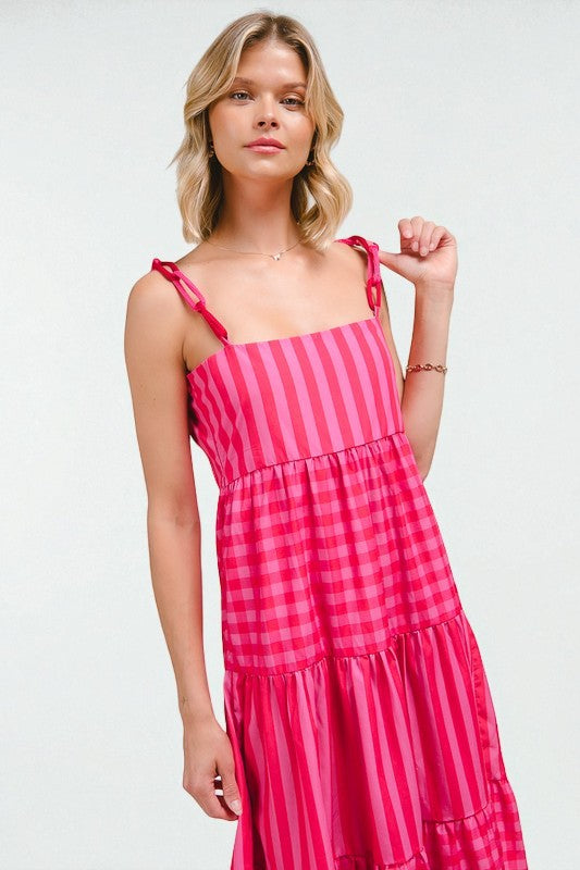 Woman wearing a pink checkered dress against a white background