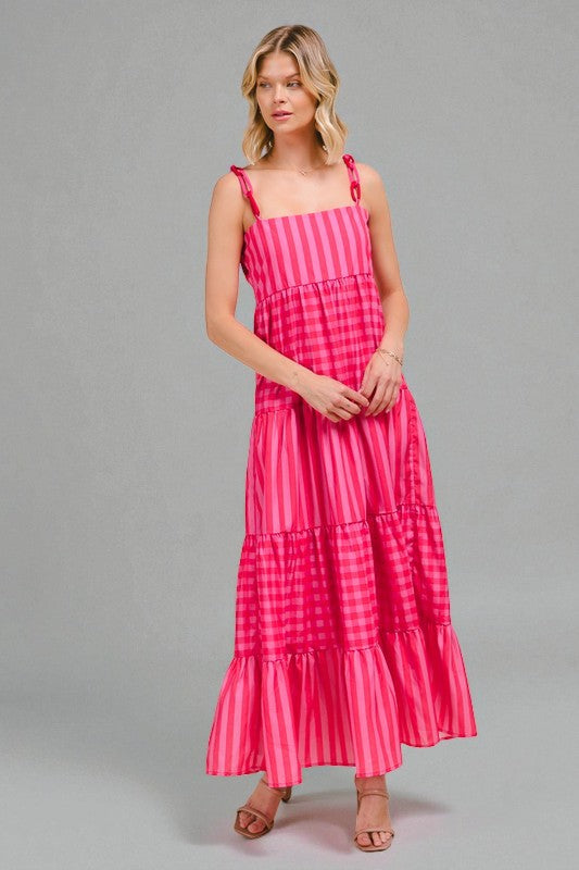 Woman wearing a pink striped dress on a gray background