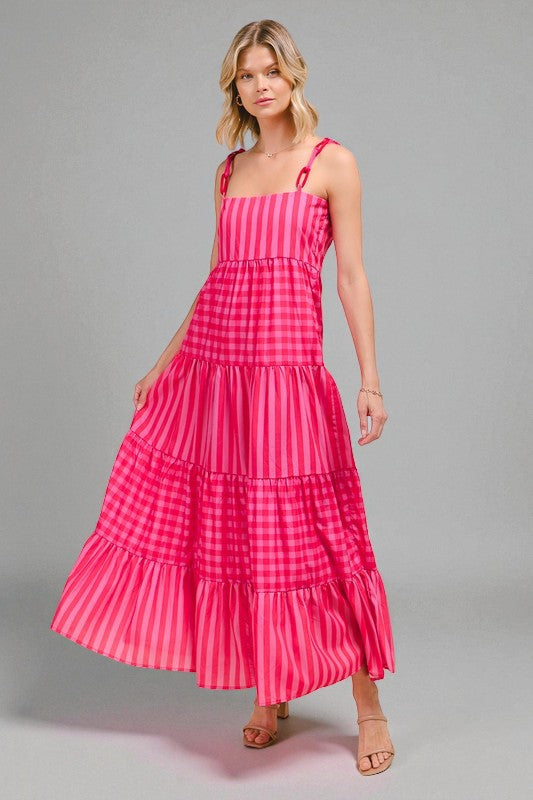 Woman wearing a pink checkered dress on a gray background