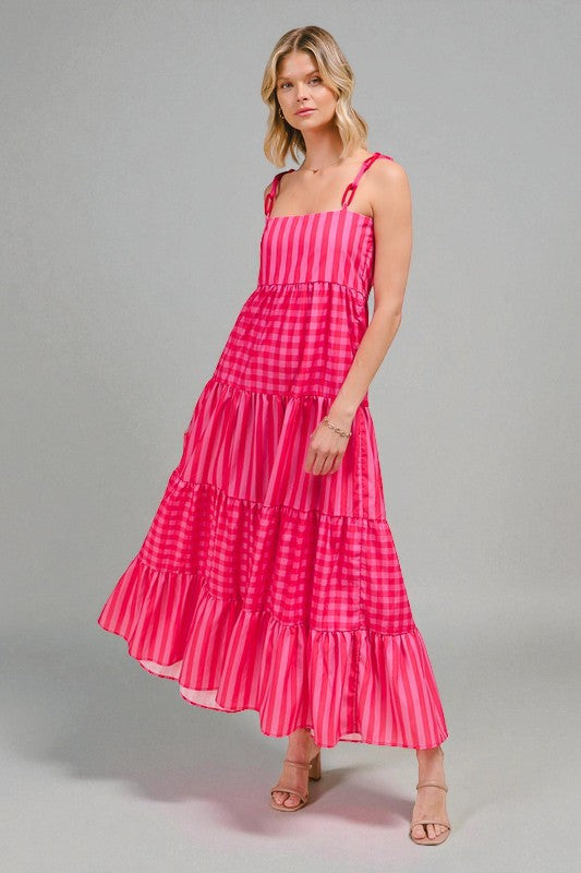 Woman wearing a pink checkered dress on a gray background