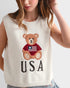 White sleeveless top with teddy bear and 'USA' text design worn by a person.