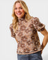 Woman wearing a floral blouse with a plain background