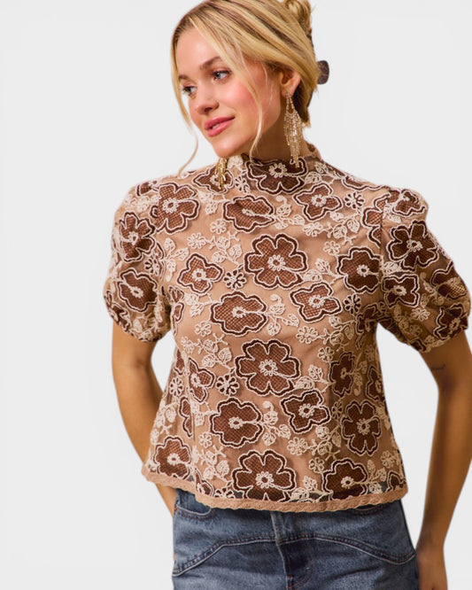 Woman wearing a floral blouse with a plain background