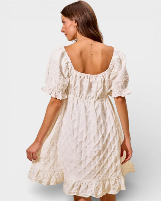 Woman wearing a white dress with a plain background