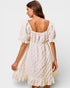 Woman wearing a white dress with a plain background
