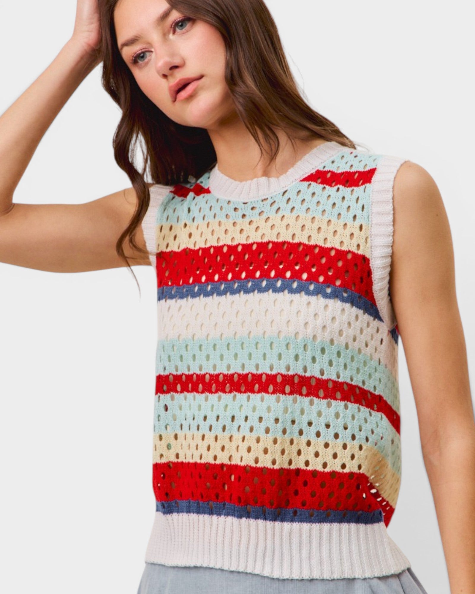 Woman wearing a colorful striped sleeveless top against a plain background