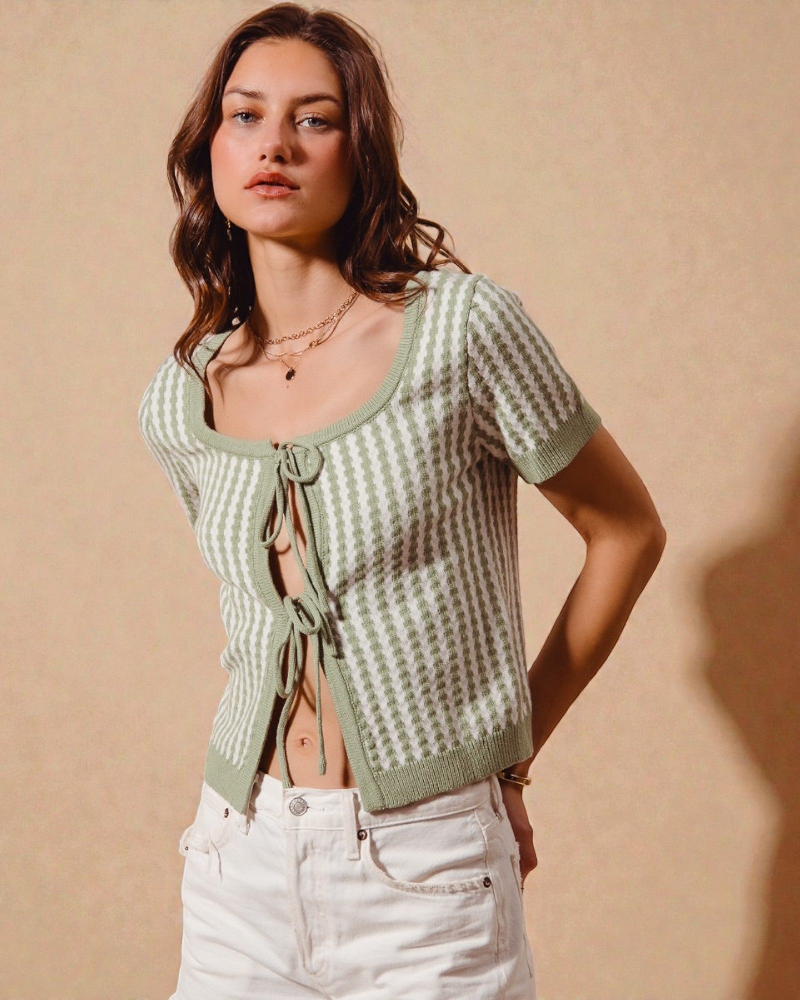 Woman wearing a green patterned top with a beige background