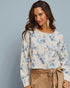 Woman wearing a floral blouse with a plain background