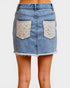 Denim skirt with floral pocket designs on a white background