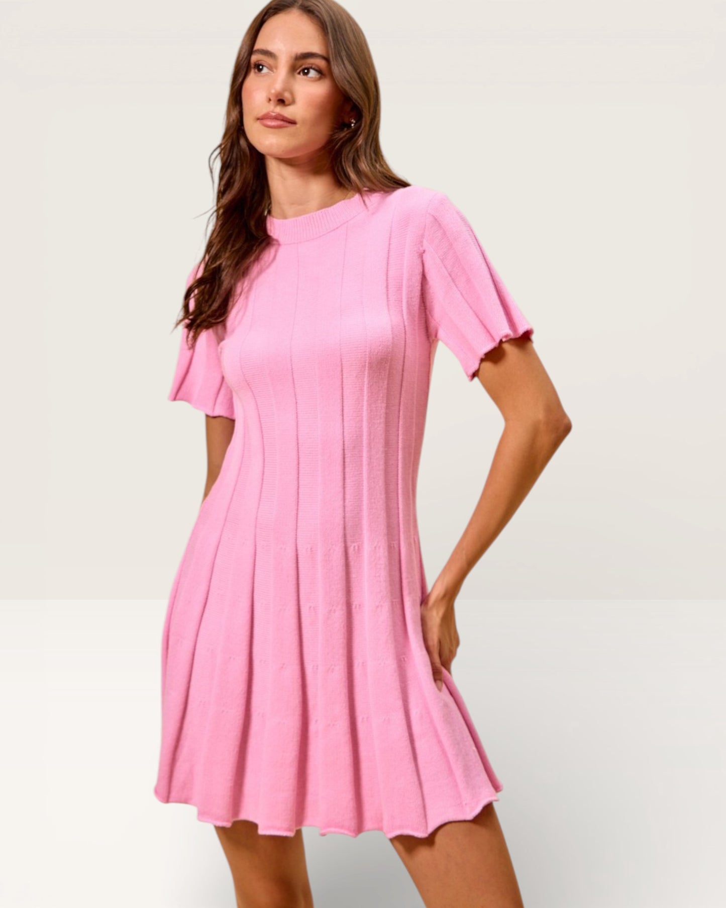 Woman wearing a pink dress on a light gray background