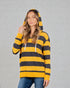 Woman wearing a yellow and black striped hoodie against a gray brick wall.