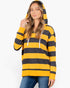 A woman wearing a yellow and black horizontally striped pullover hoodie with white drawstrings, paired with blue jeans, against a plain white background.
