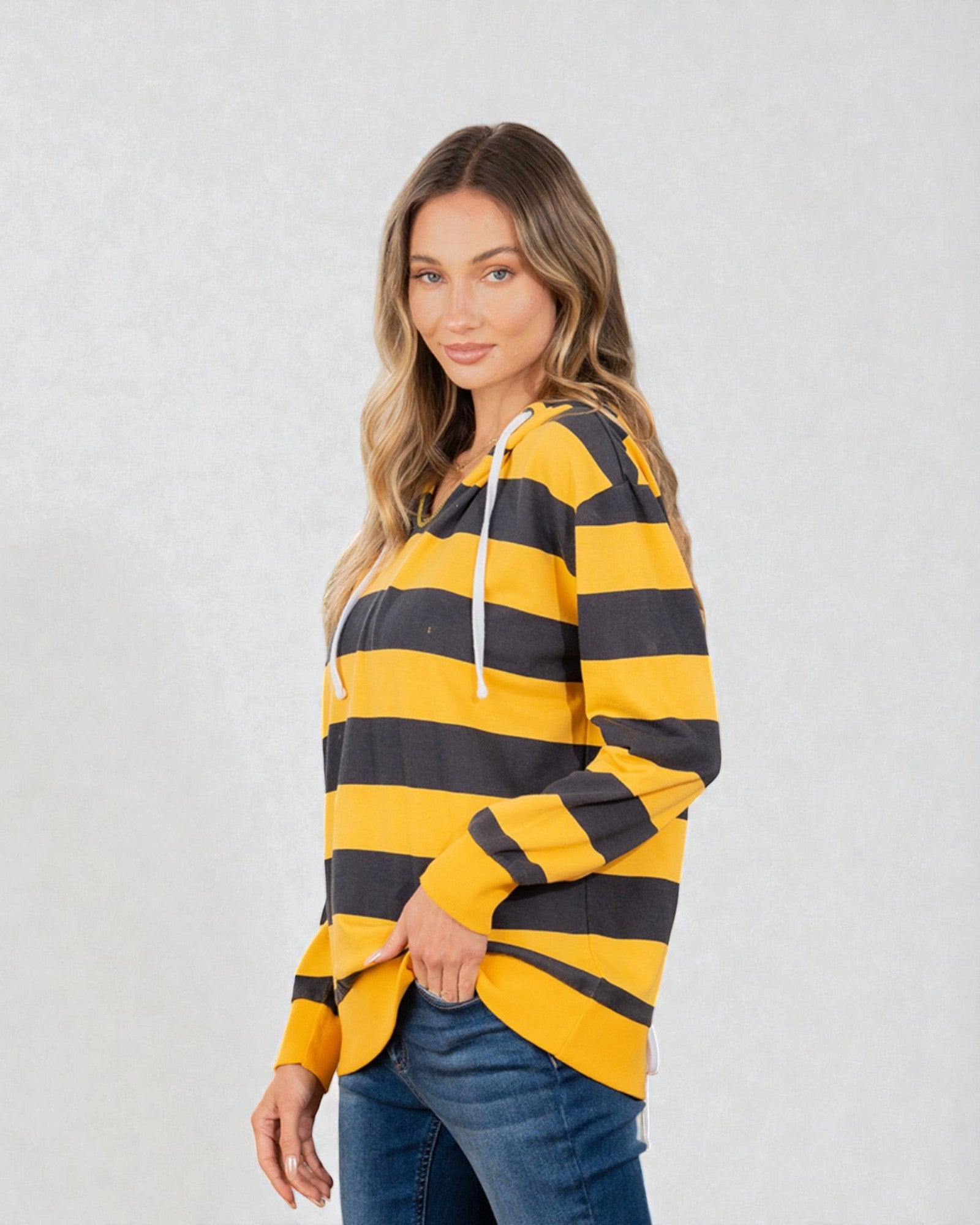 Woman wearing a yellow and black striped hoodie on a white background