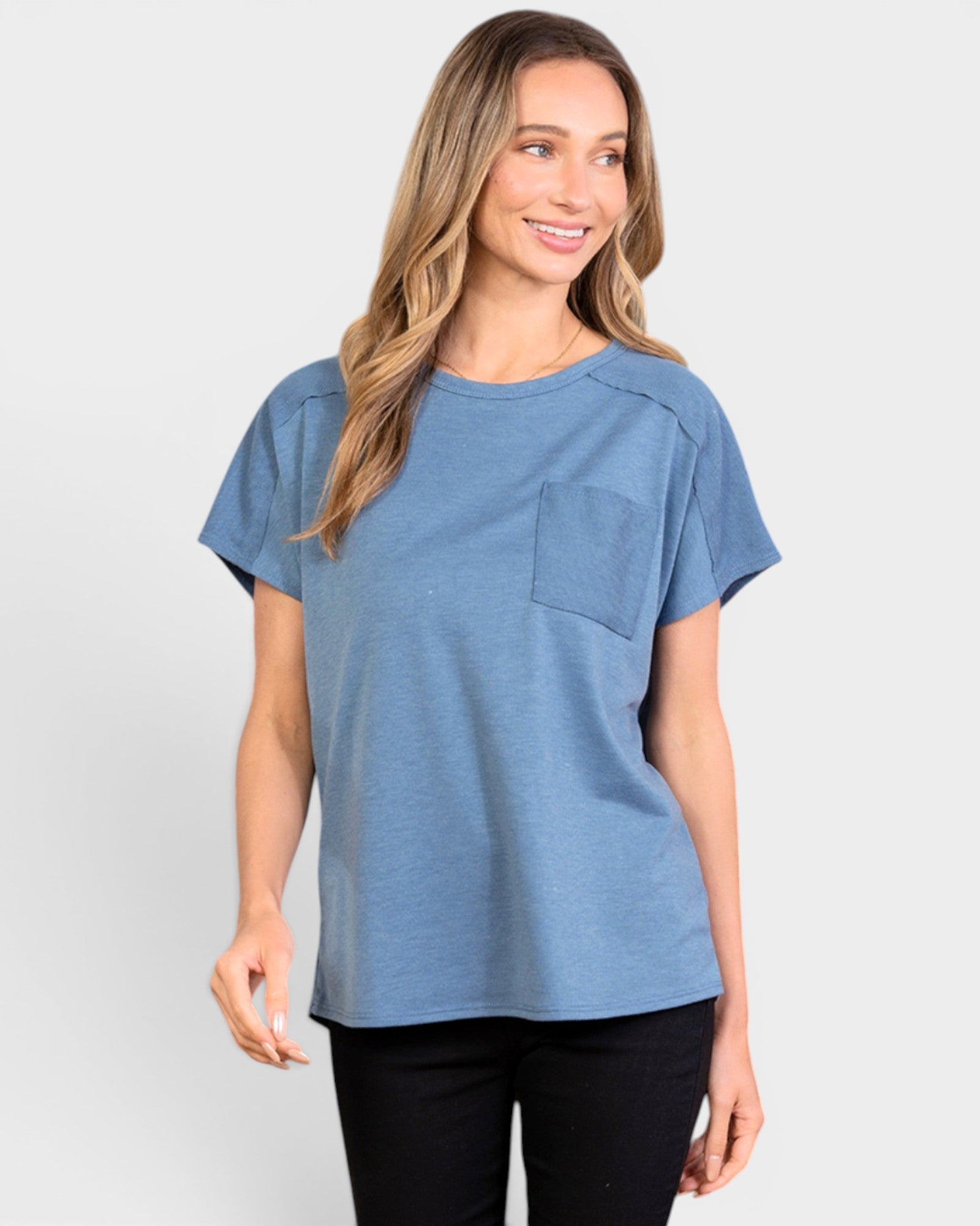Woman wearing a blue t-shirt with a pocket on a light gray background