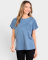 Woman wearing a blue t-shirt with a pocket on a light gray background