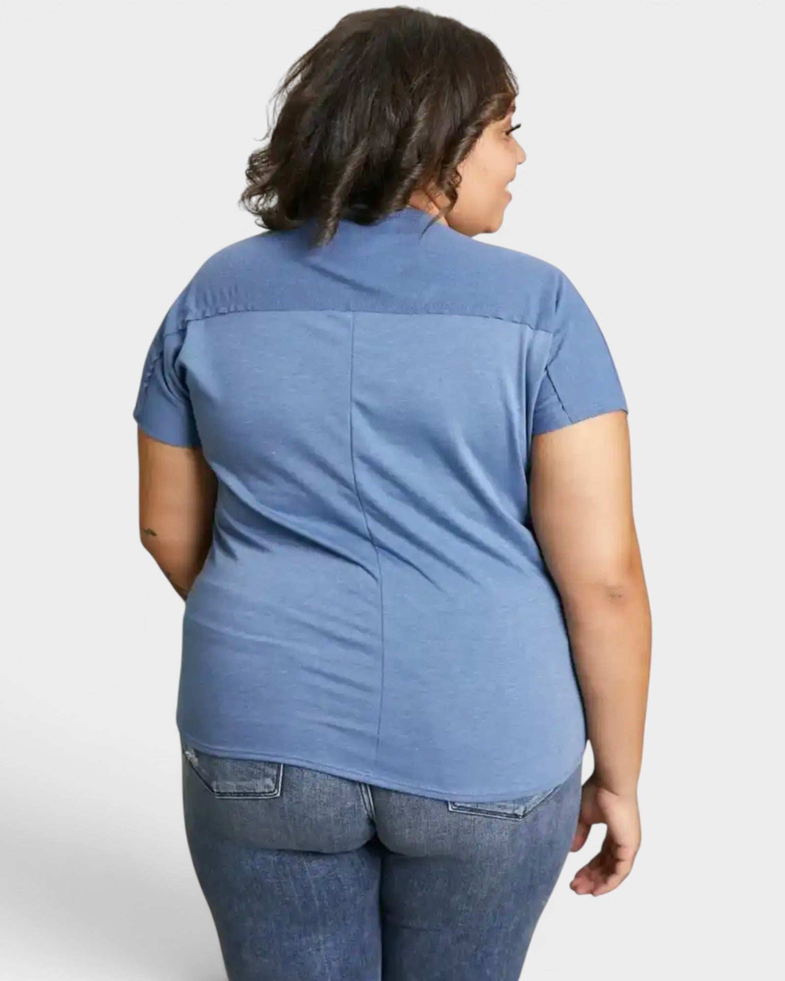 Person wearing a blue shirt and jeans on a white background