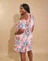 Woman wearing a floral dress against a beige background