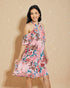 Woman wearing a pink floral dress against a beige background