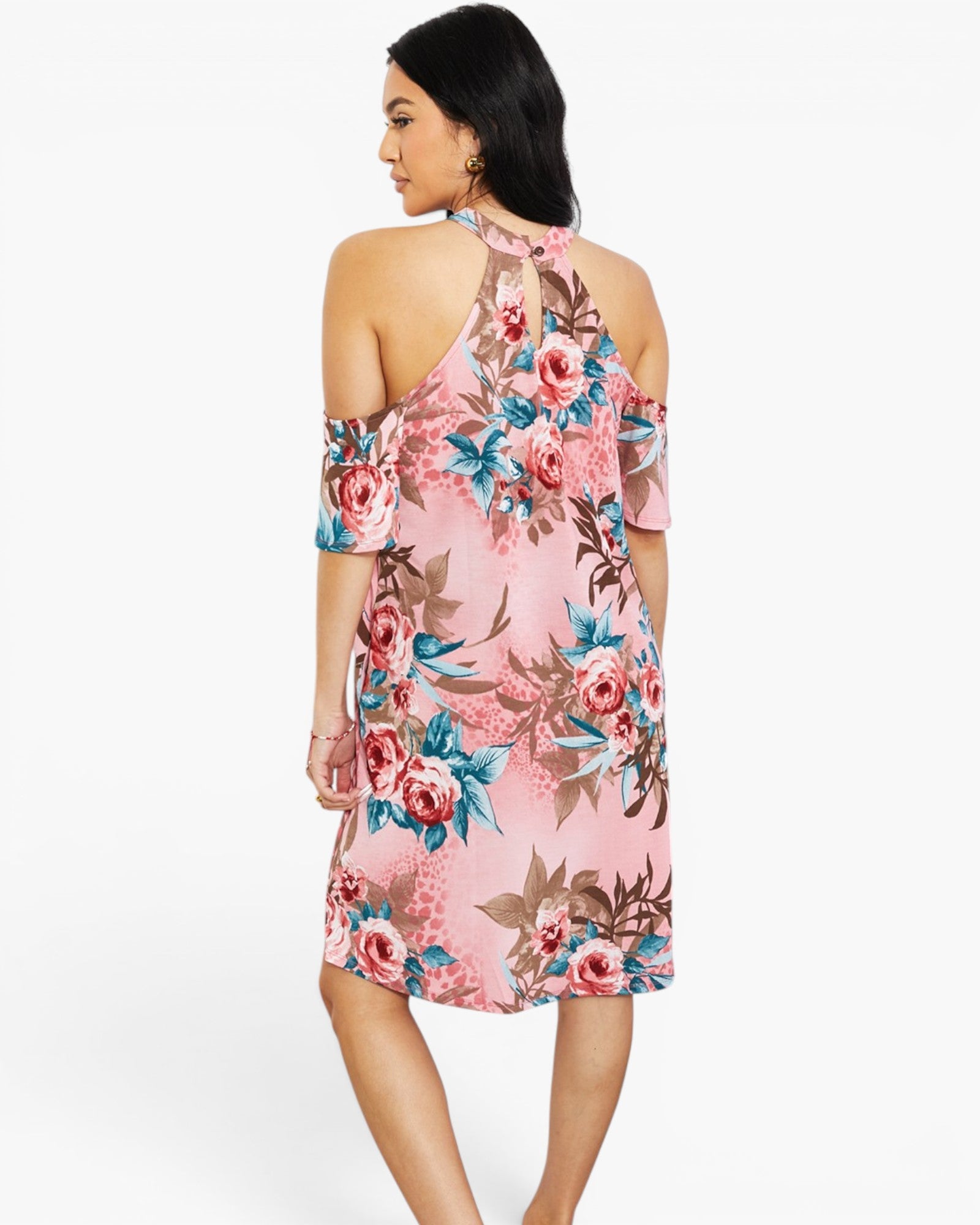 A woman modeling a pink cold-shoulder floral dress with blue and brown accents, shown from the back against a plain white background.