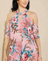 Woman wearing a pink floral dress against a beige background