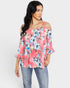 Woman wearing a floral off-shoulder top and jeans on a white background