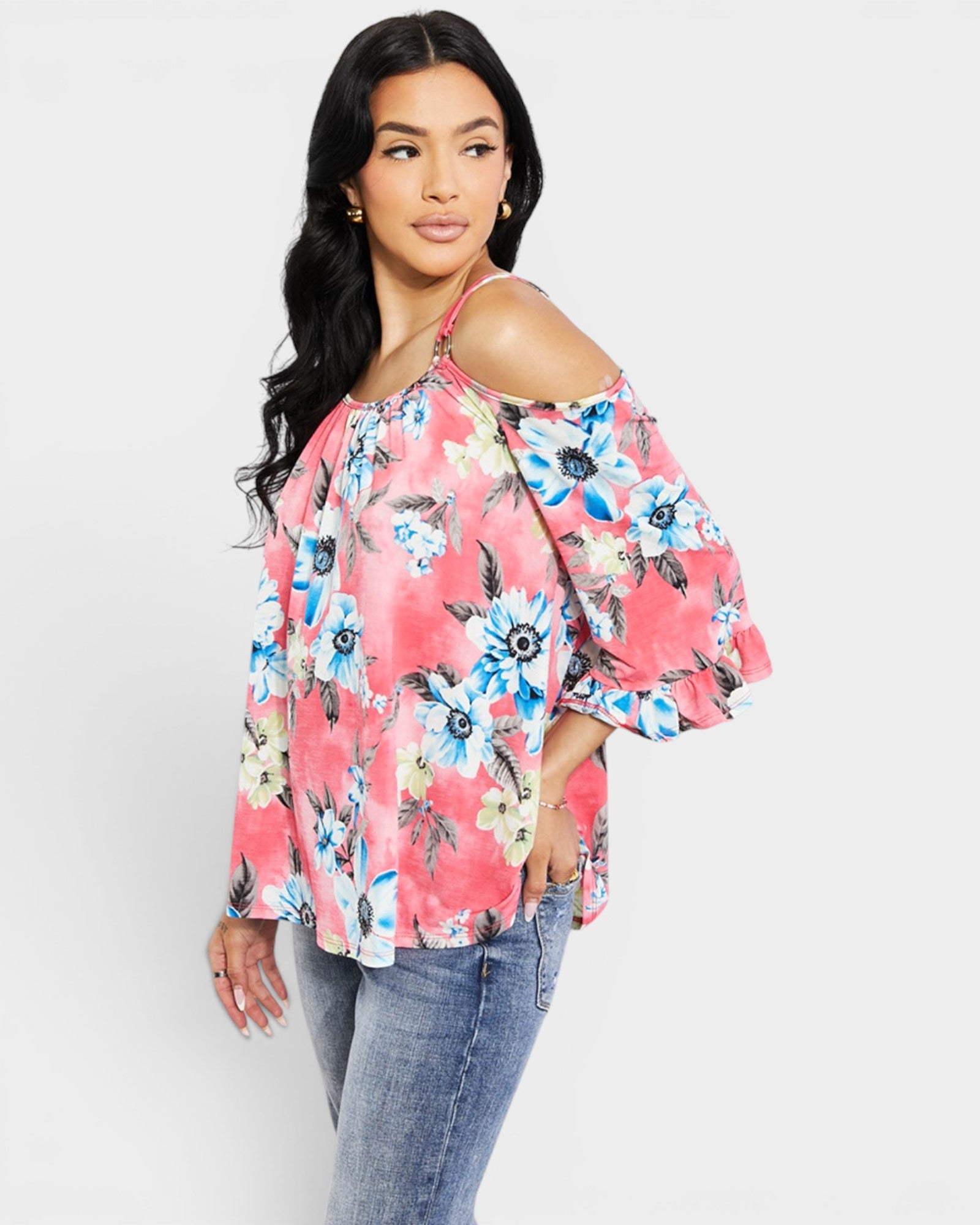 Woman wearing a floral off-shoulder top with a white background