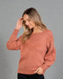 Woman wearing a brown sweater against a gray background