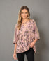 Woman wearing a patterned blouse against a gray background