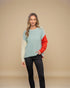 Woman wearing a multicolored sweater with a beige background