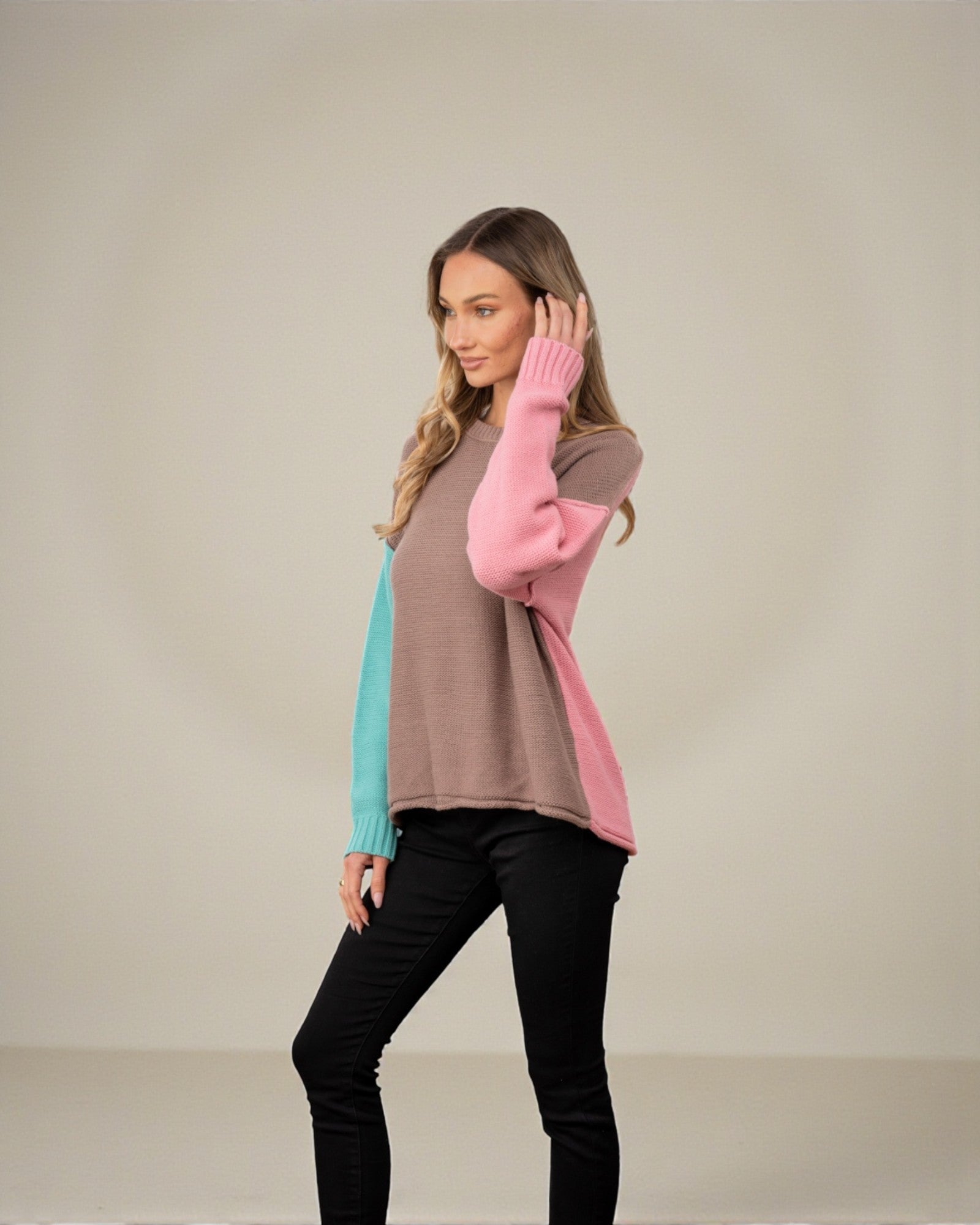 Woman wearing a colorful sweater with a neutral background